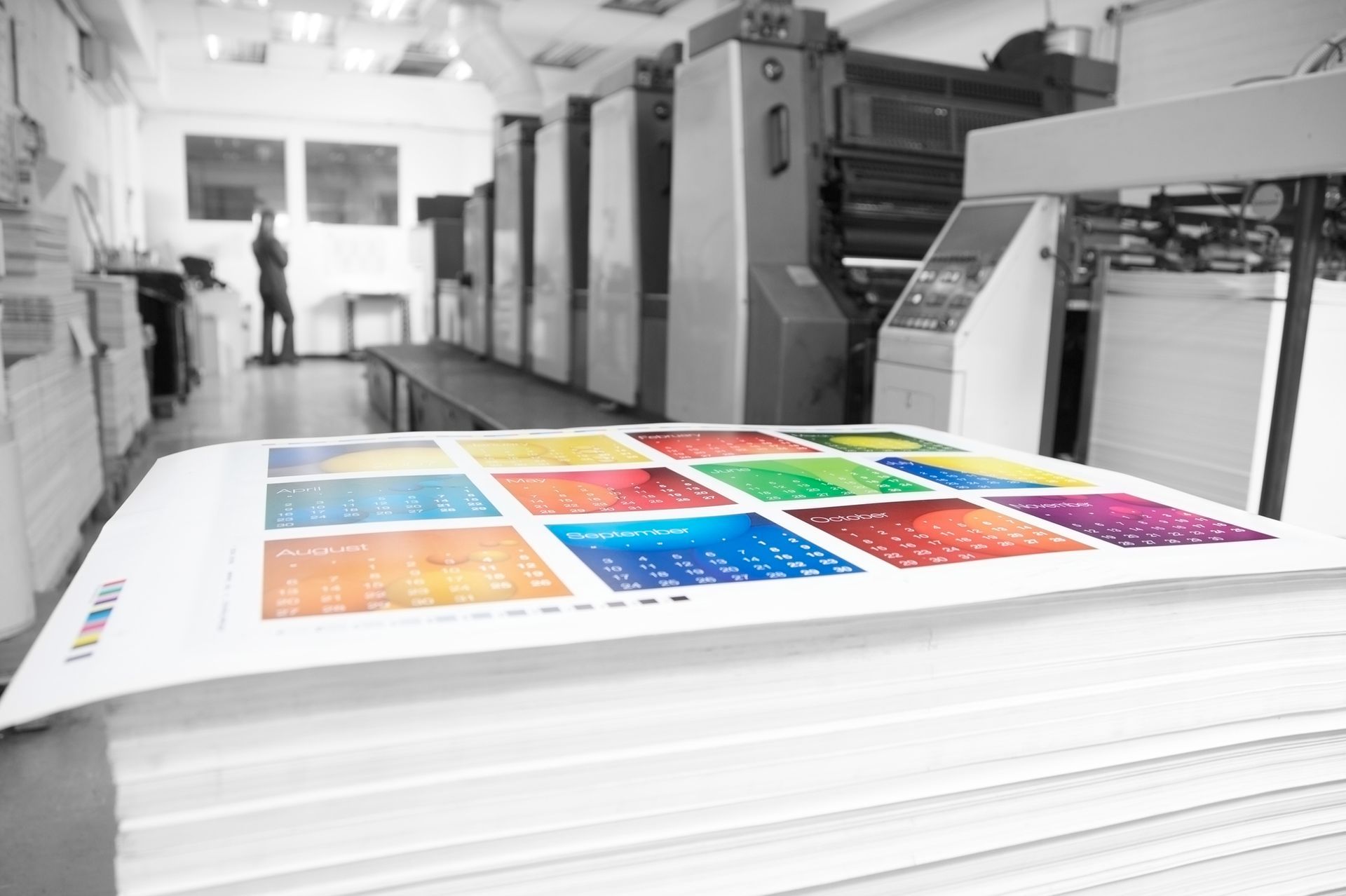 A stack of calendars with a rainbow of colors on them in a printing factory. - Port Saint John, FL - Shipping Depot of Port St John