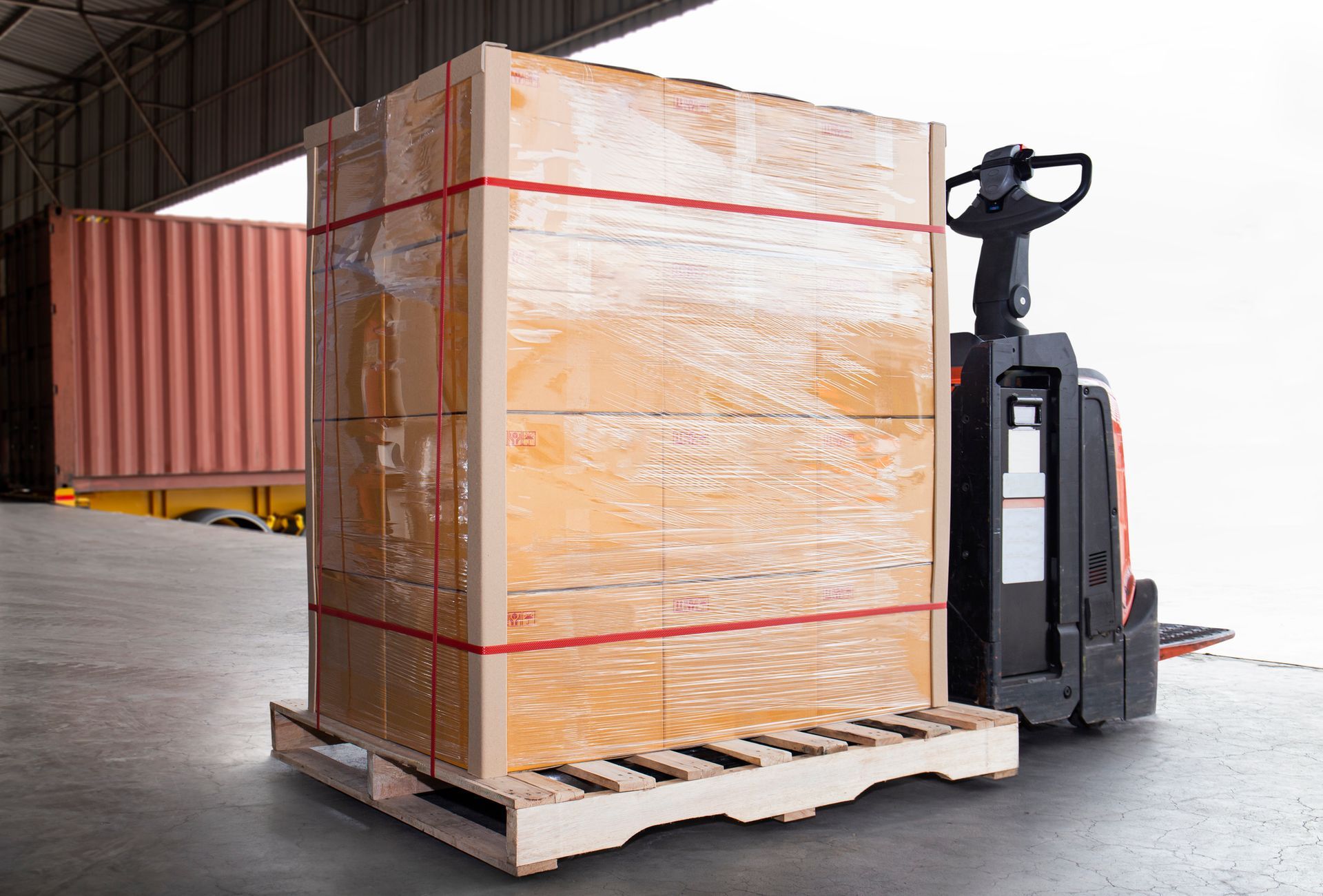 A forklift is carrying a large wooden box on a wooden pallet. - Port Saint John, FL - Shipping Depot of Port St John