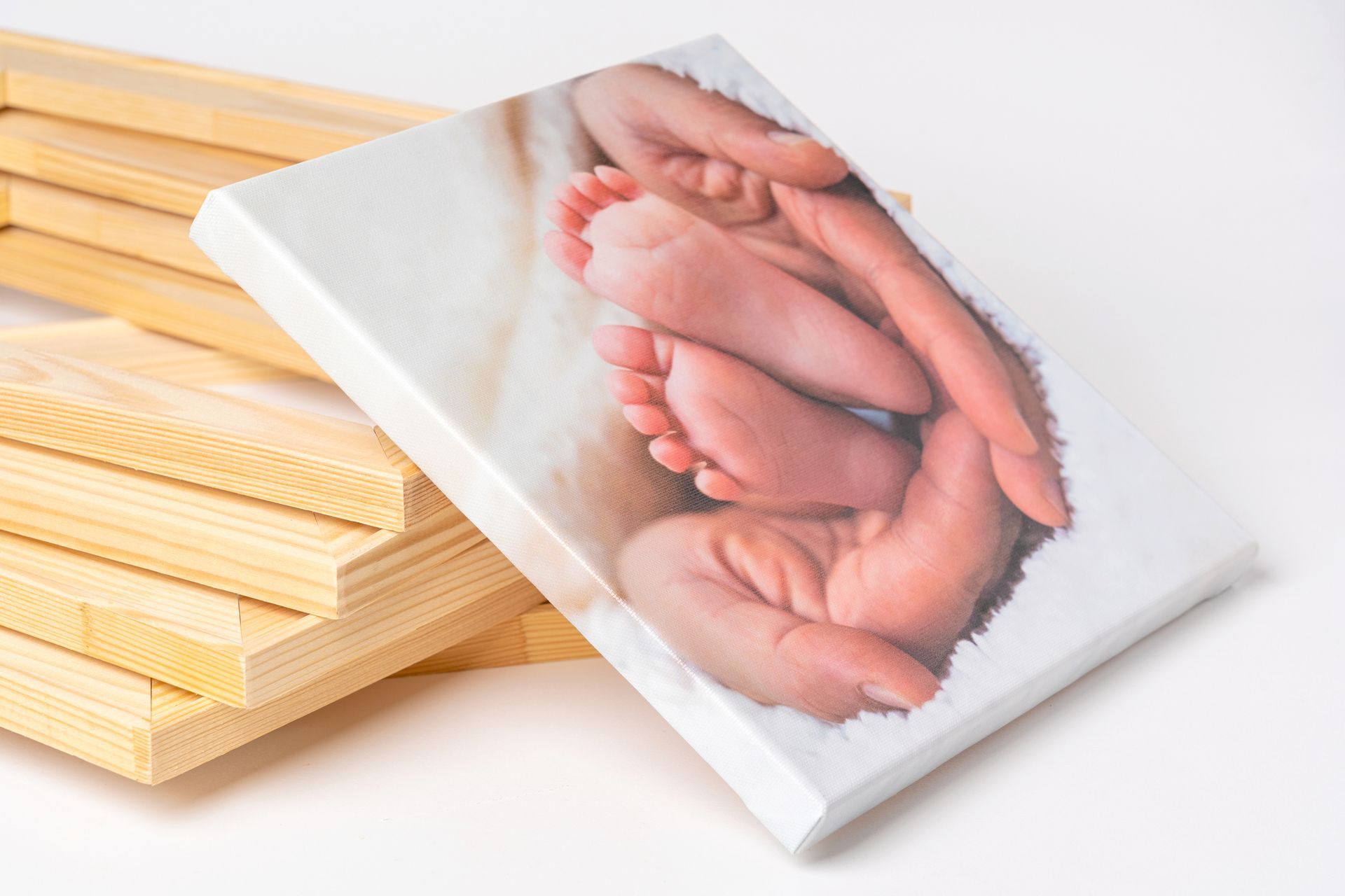 A picture of a baby's feet on a canvas next to a stack of wooden frames. - Port Saint John, FL - Shipping Depot of Port St John