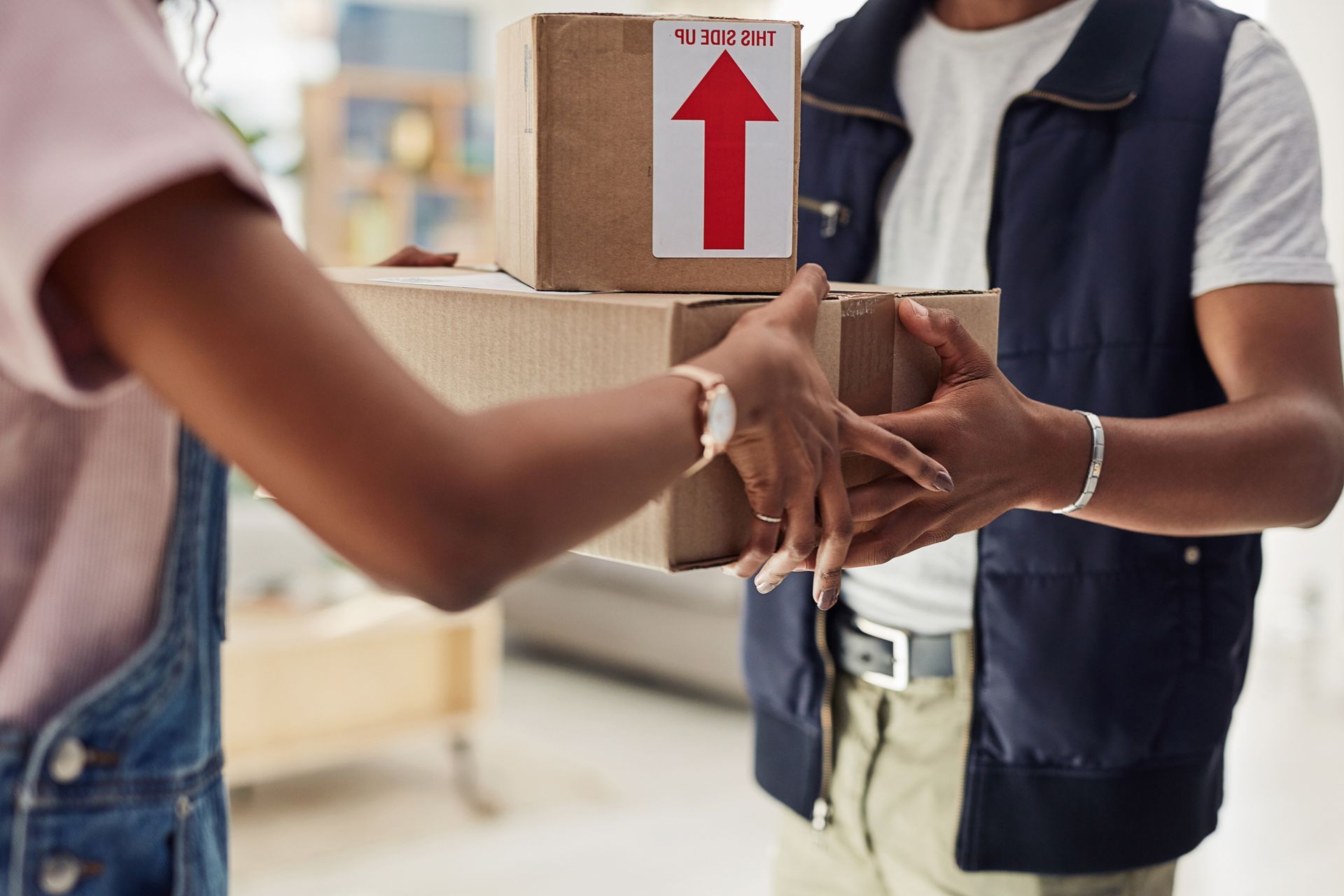 A delivery man is handing a package to a woman. - Port Saint John, FL - Shipping Depot of Port St John