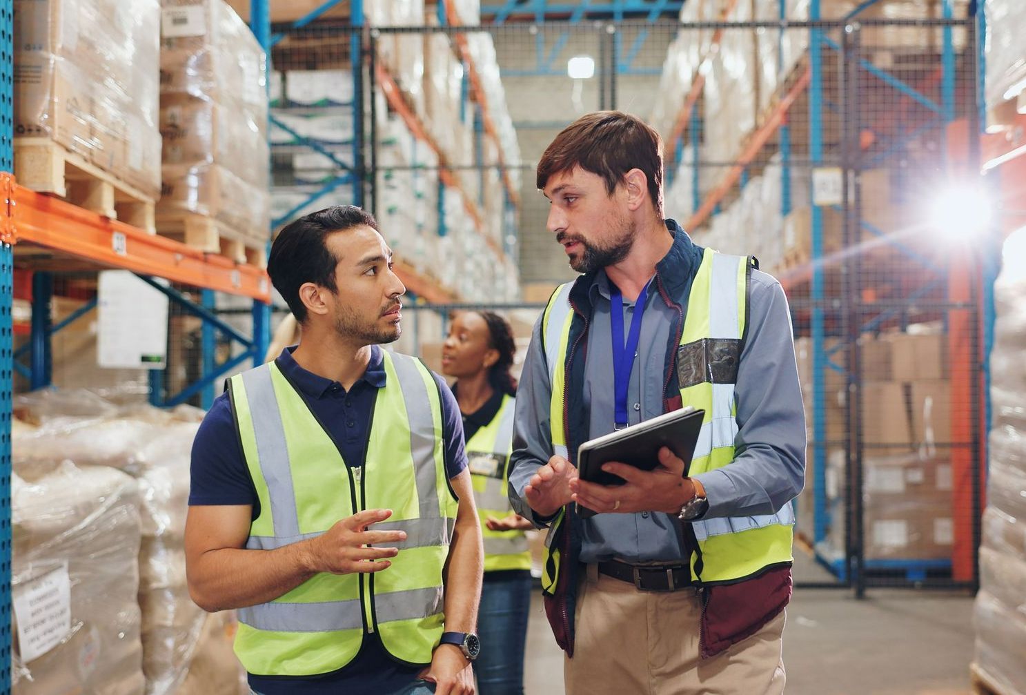 Two men are standing in a warehouse looking at a tablet. - Port Saint John, FL - Shipping Depot of Port St John