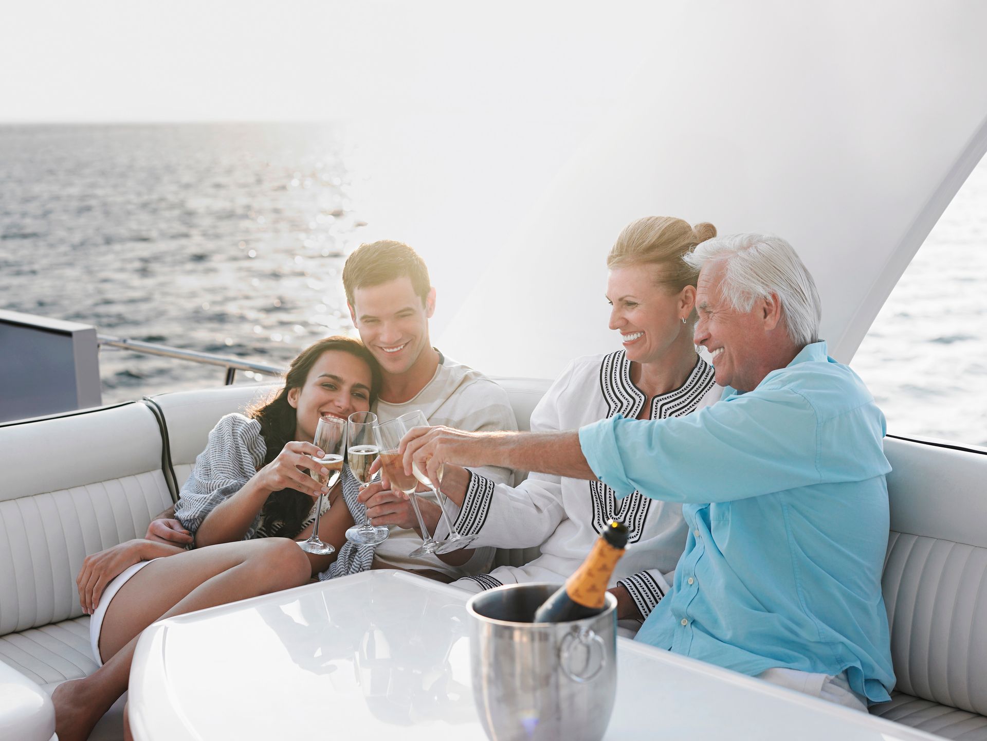 A group of people are sitting on a boat toasting with champagne.