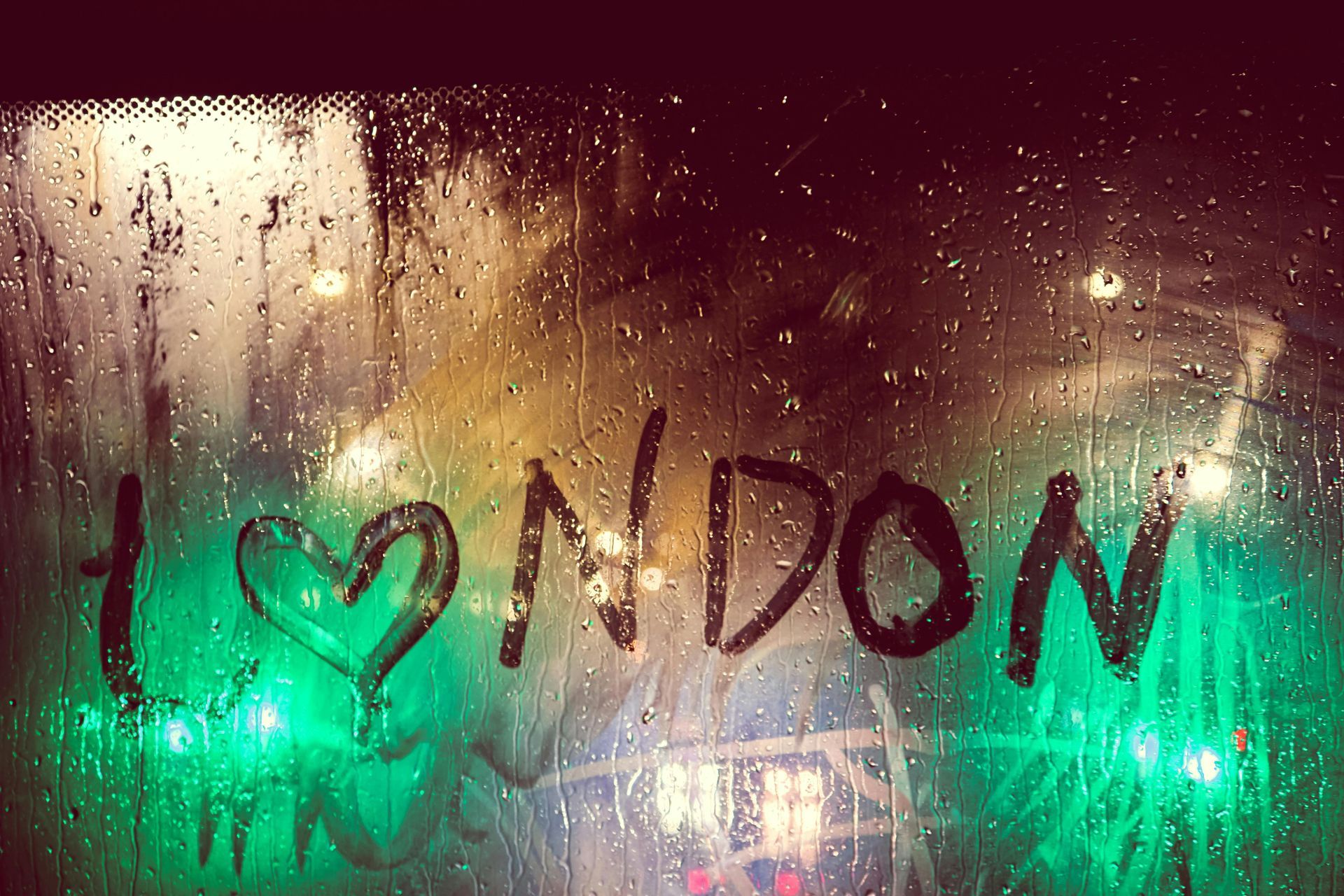 The word london is written on a wet window