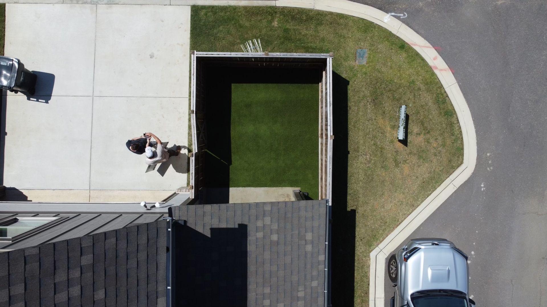 An aerial view of a house with a car parked in front of it