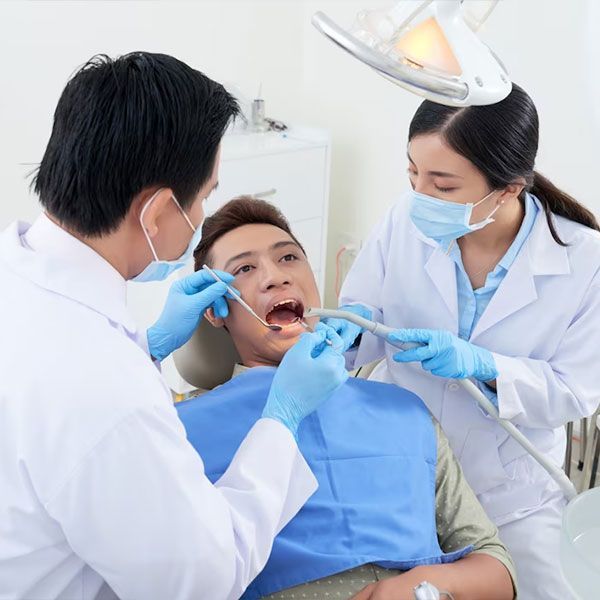 Man Getting Teeth Inspected by Two Dentists | Teeth Cleaning in Houston TX 77042