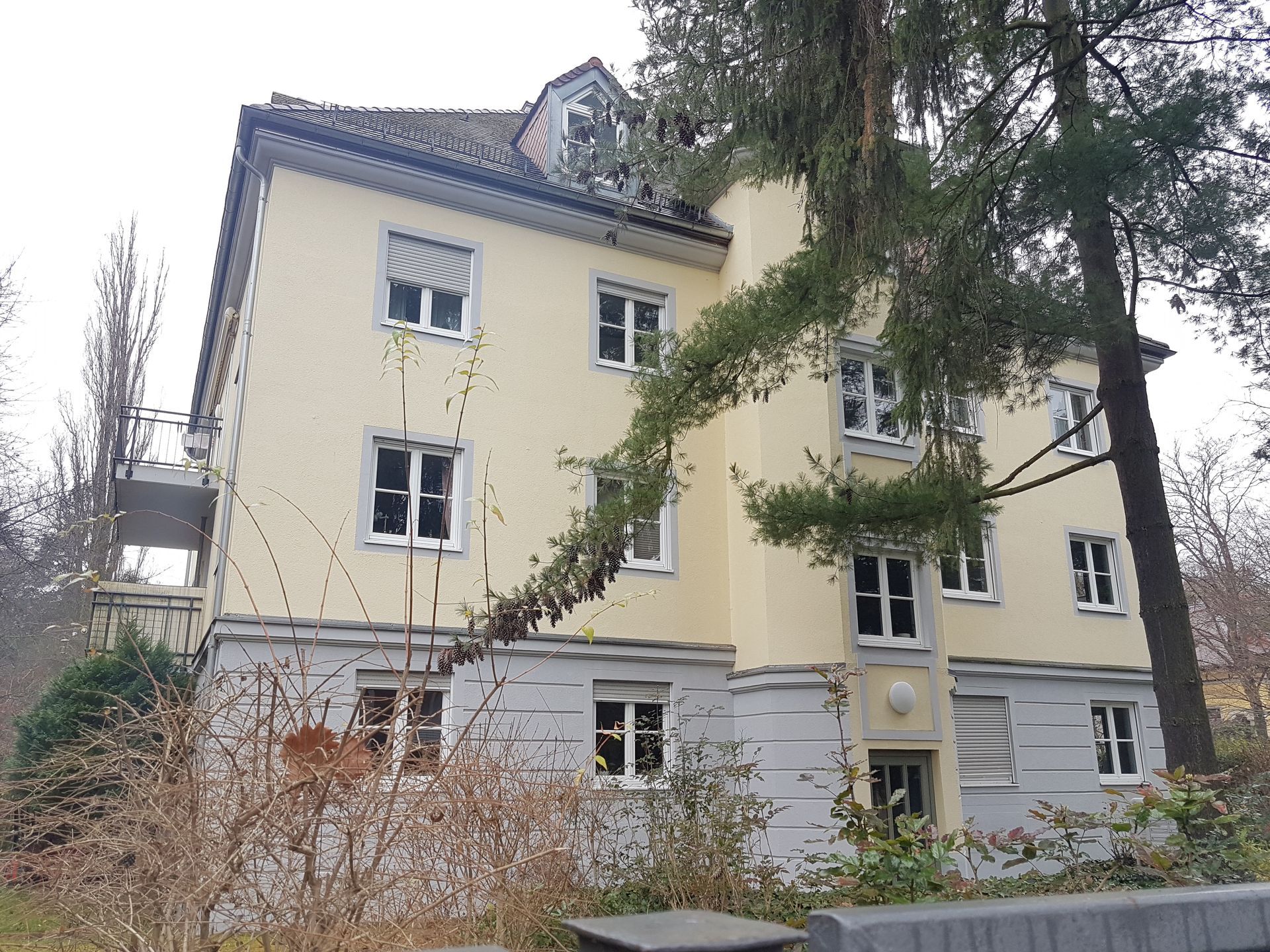 Ein großes Gebäude mit vielen Fenstern und Bäumen davor