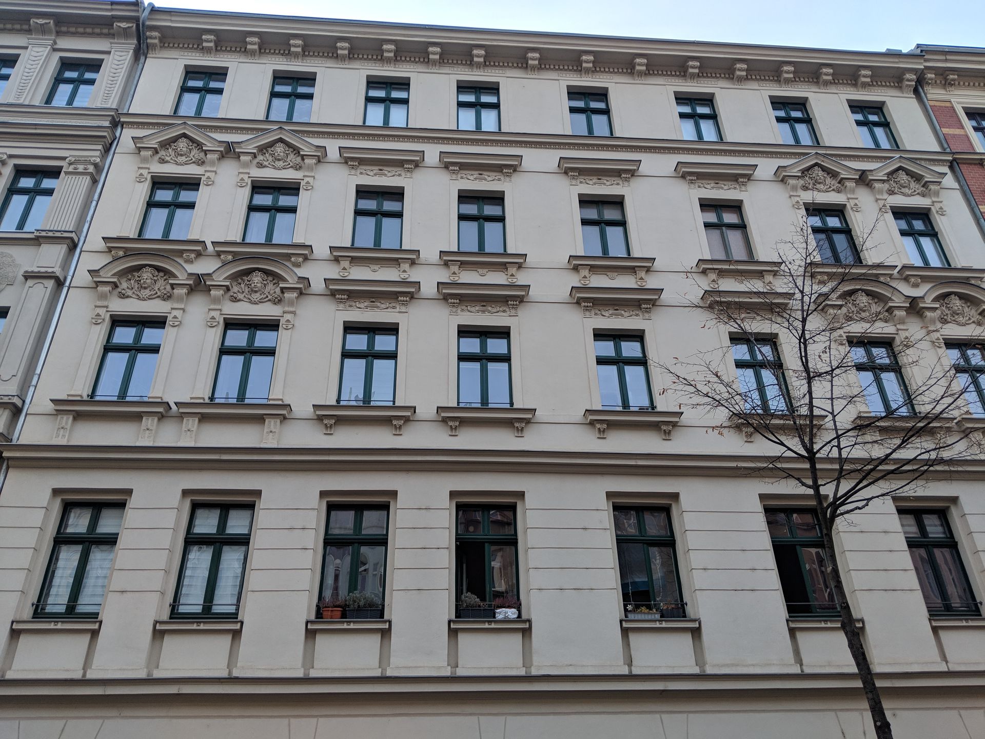 Ein Gebäude mit vielen Fenstern und einem Baum davor