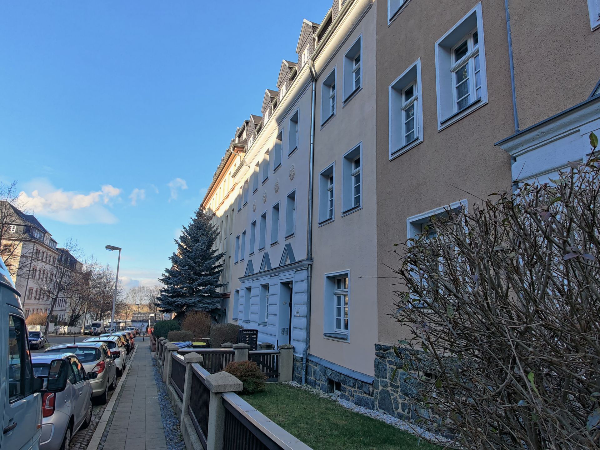 Eine Reihe von Gebäuden mit am Straßenrand geparkten Autos.