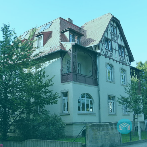 Ein schönes großes weißes Haus mit einem braunen Dach ist von Bäumen umgeben