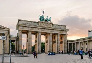 Eine Gruppe von Menschen steht vor einem großen Gebäude.