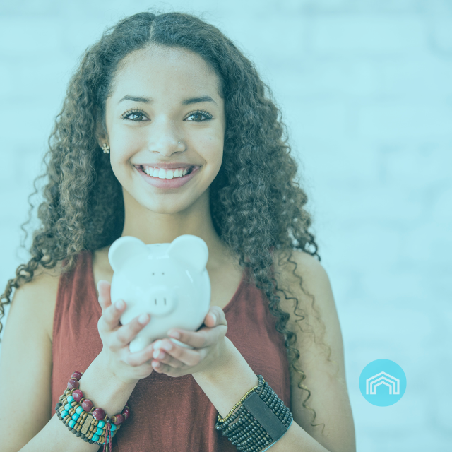 Eine Frau hält ein Sparschwein in ihren Händen und lächelt.