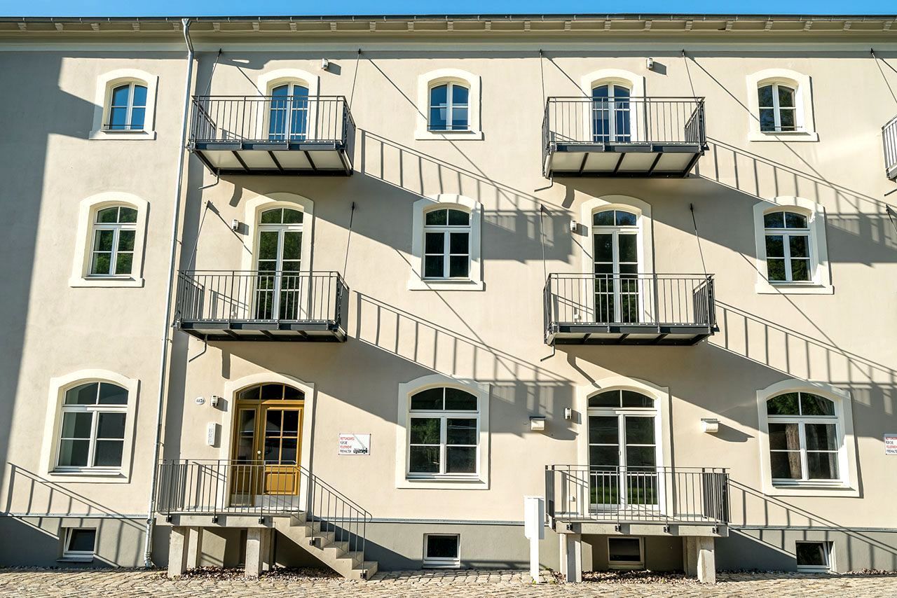 Ein großes weißes Gebäude mit Feuerleitern an der Seite