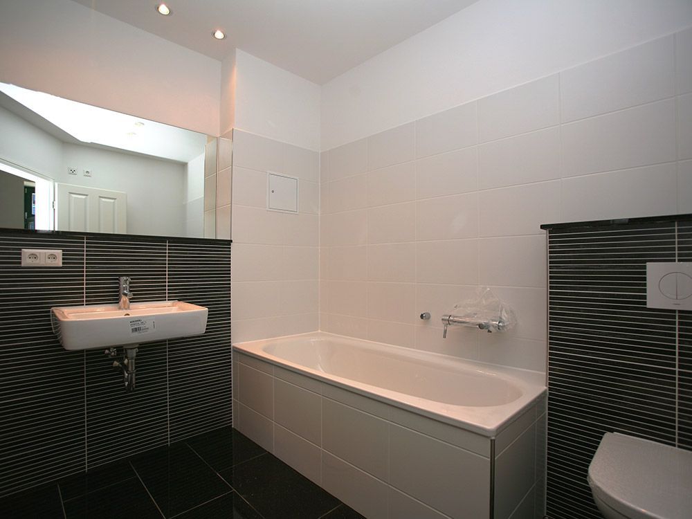 Ein Badezimmer mit Badewanne, Waschbecken, Toilette und Spiegel.