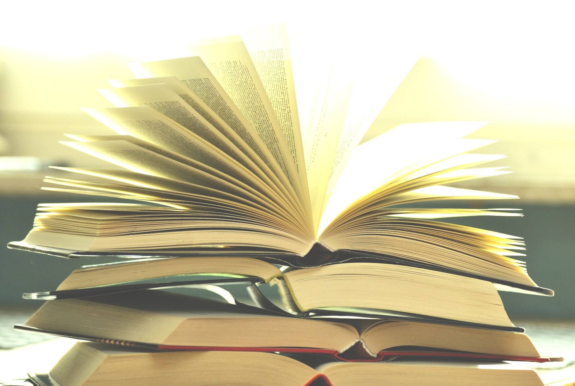 A stack of books with one being open