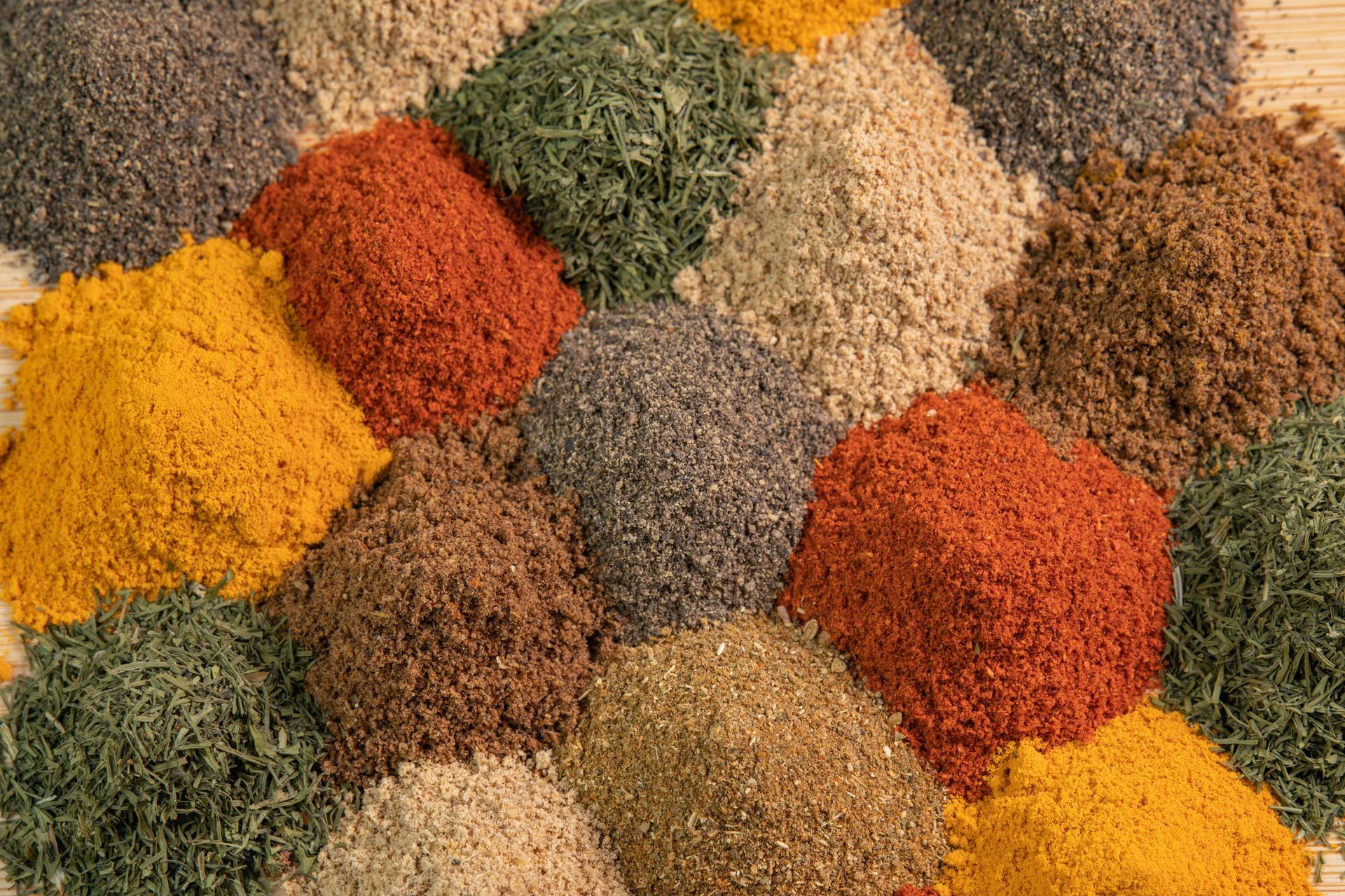 A variety of spices are stacked on top of each other on a table.