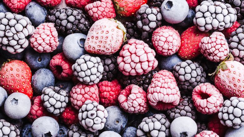 A pile of frozen berries including raspberries , blueberries , strawberries and blackberries.