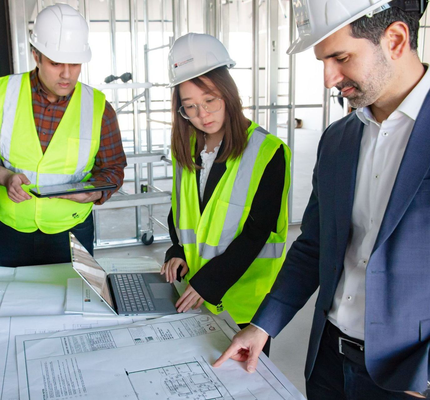 A group of construction workers are looking at a blueprint