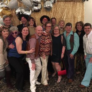 A group of people are posing for a picture in front of balloons.