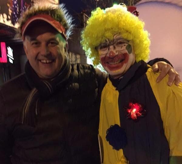 A man and a clown pose for a picture together