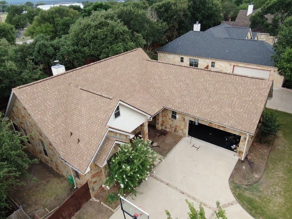 An aerial view of a house with a basketball hoop in front of it.