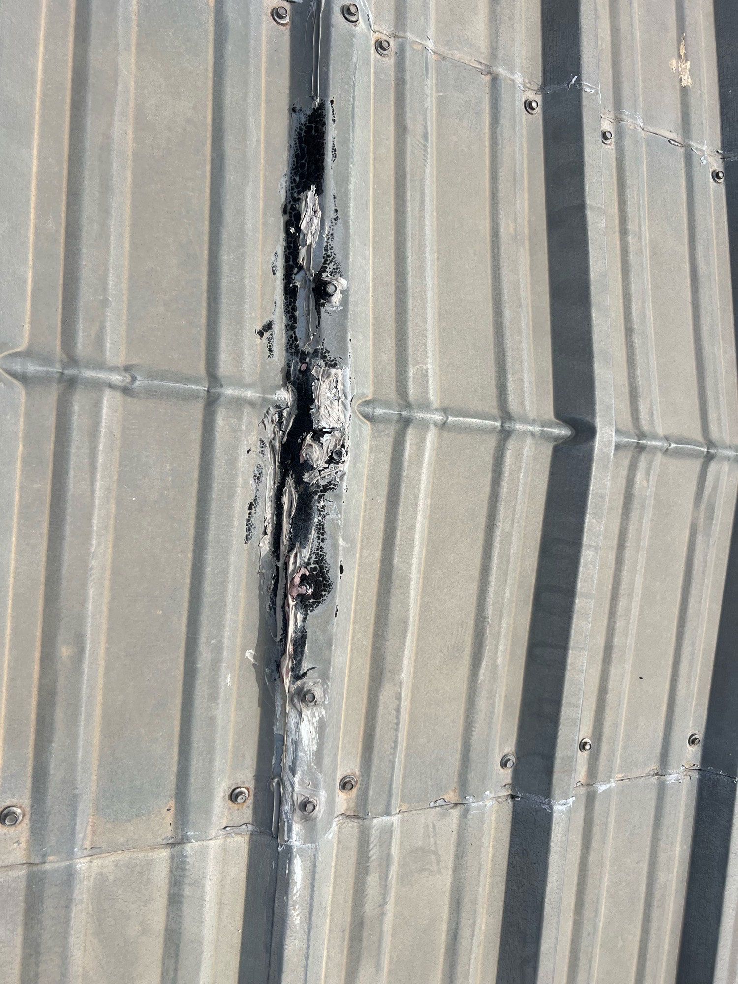 A close up of a metal roof with a hole in it