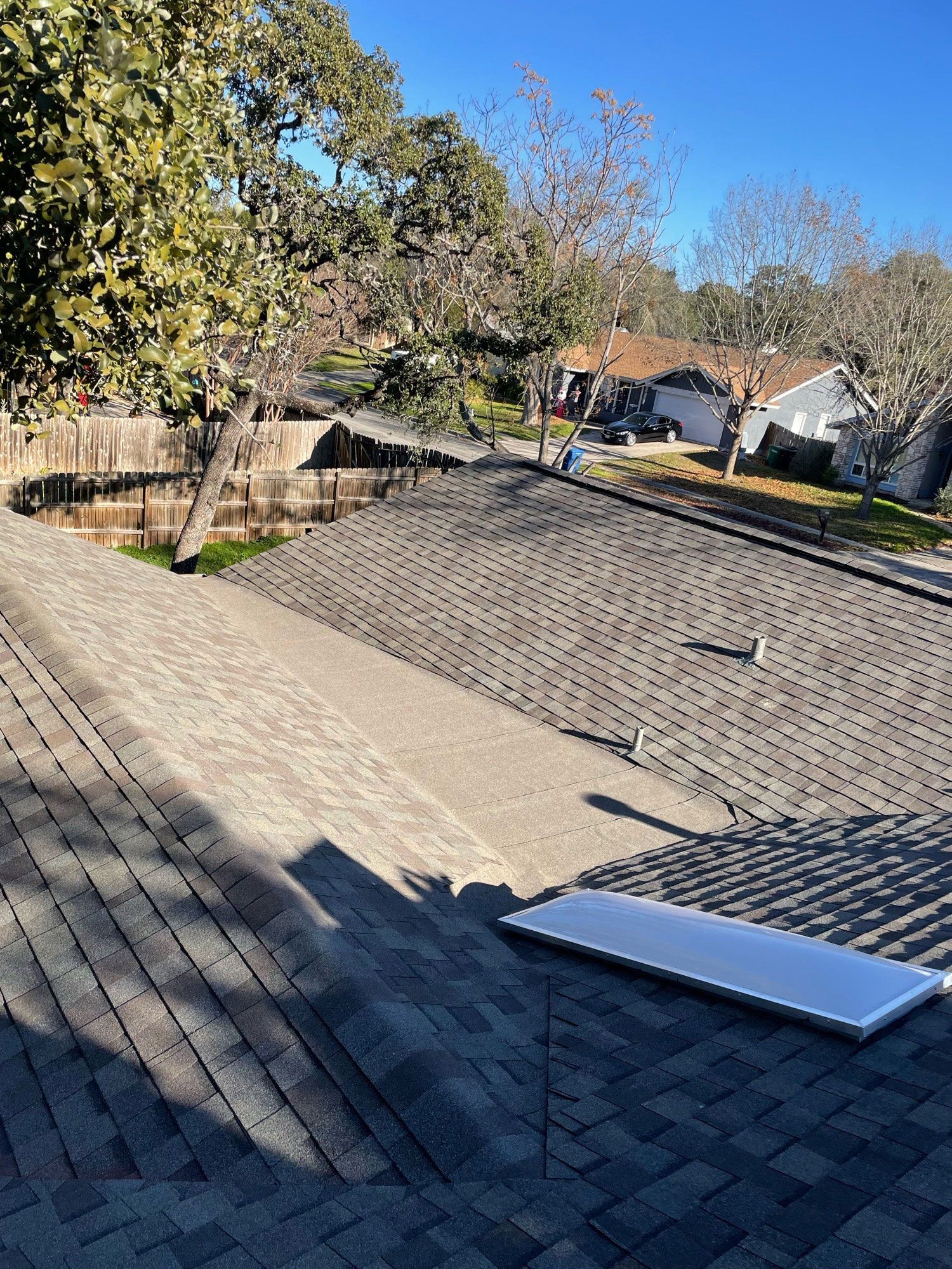 A solar panel is sitting on the roof of a house.