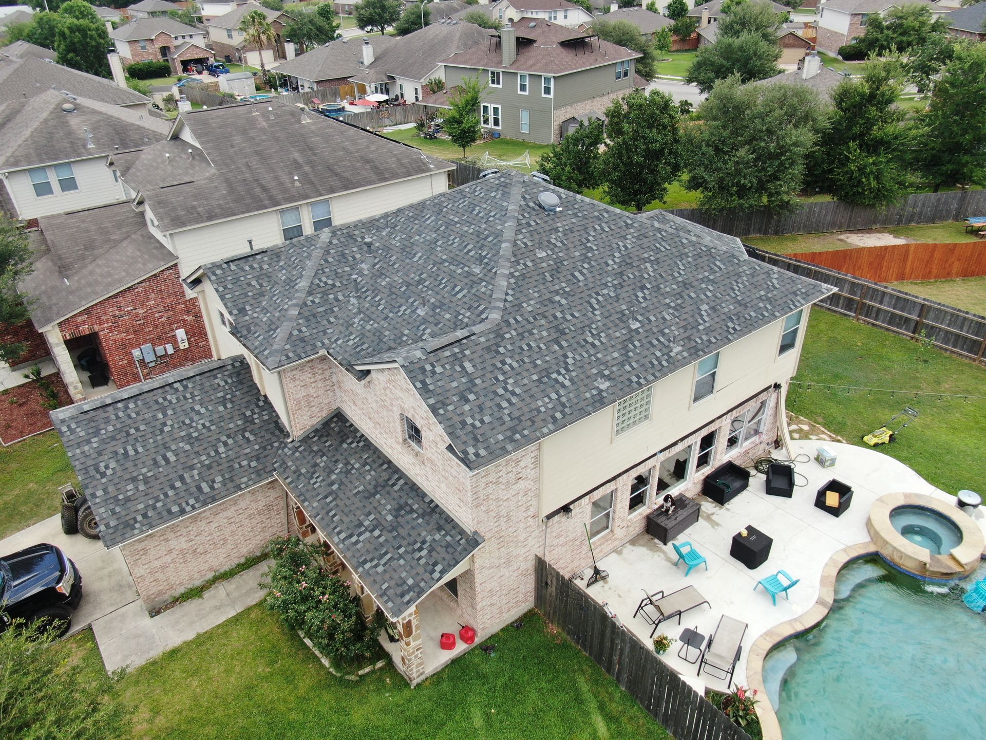 An aerial view of a large house with a pool in the backyard.