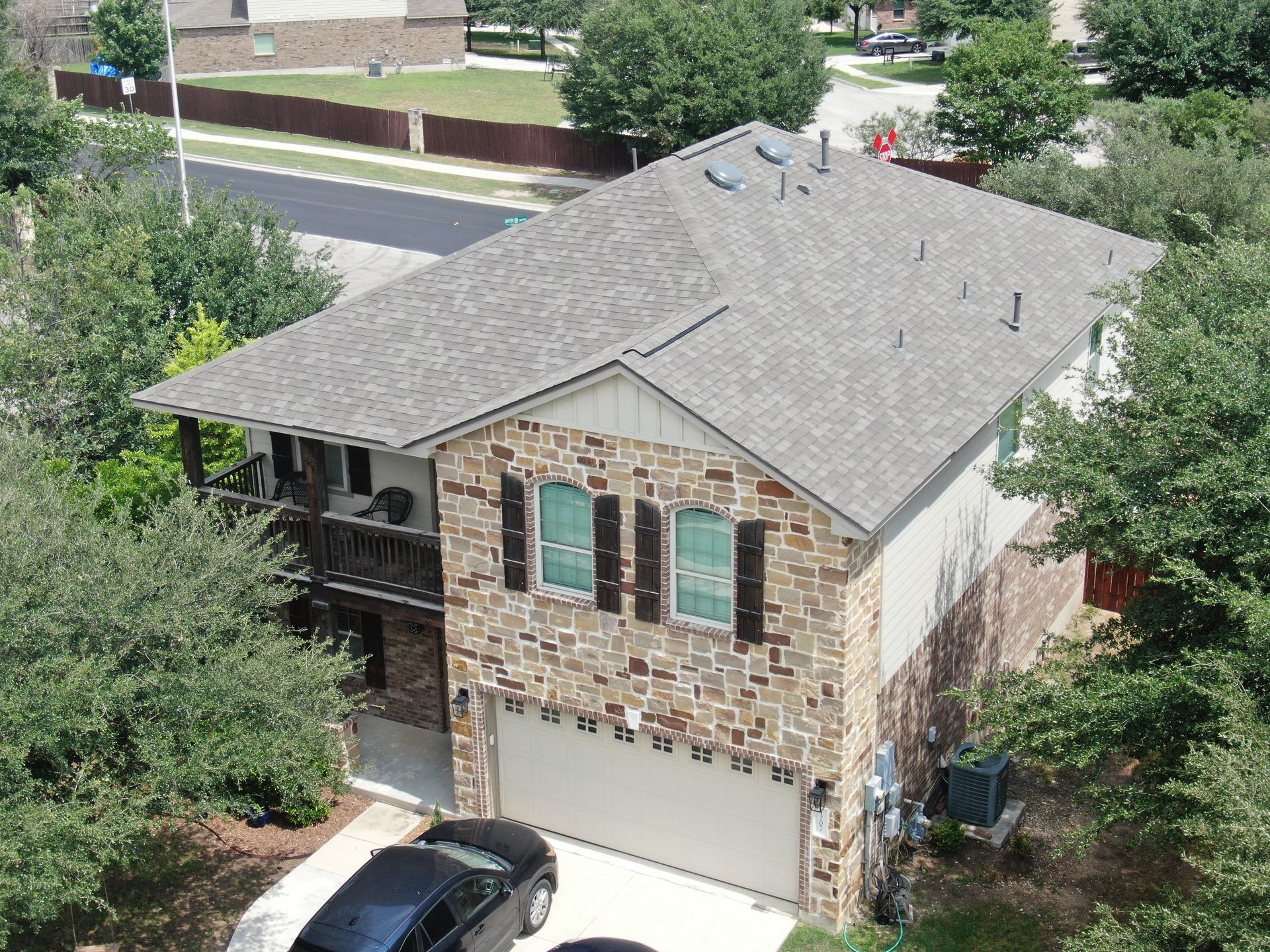 An aerial view of a house with a car parked in front of it
