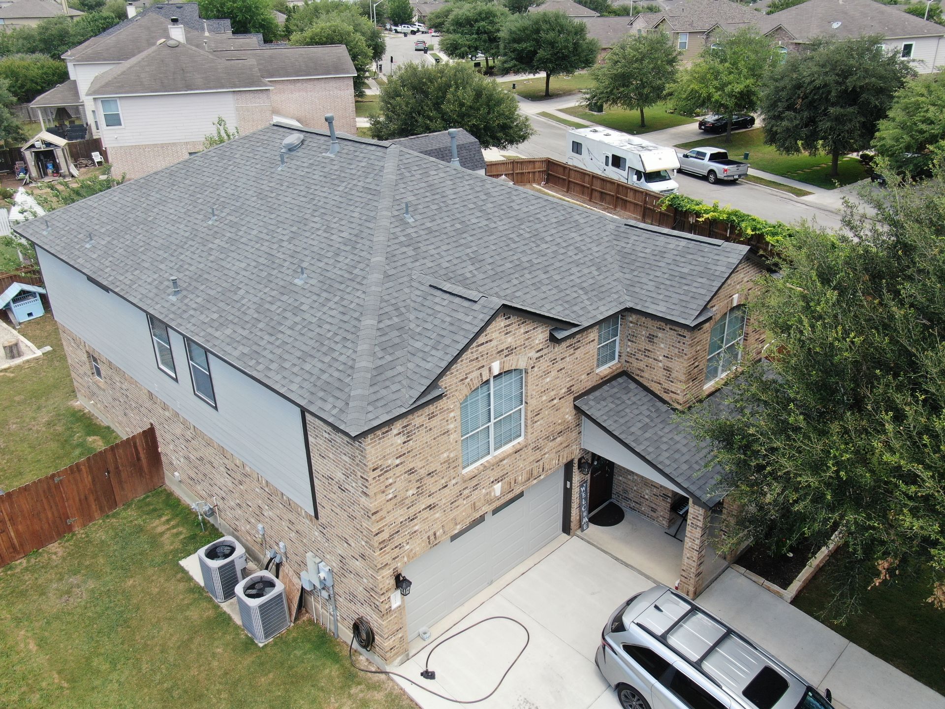 An aerial view of a house with a car parked in front of it