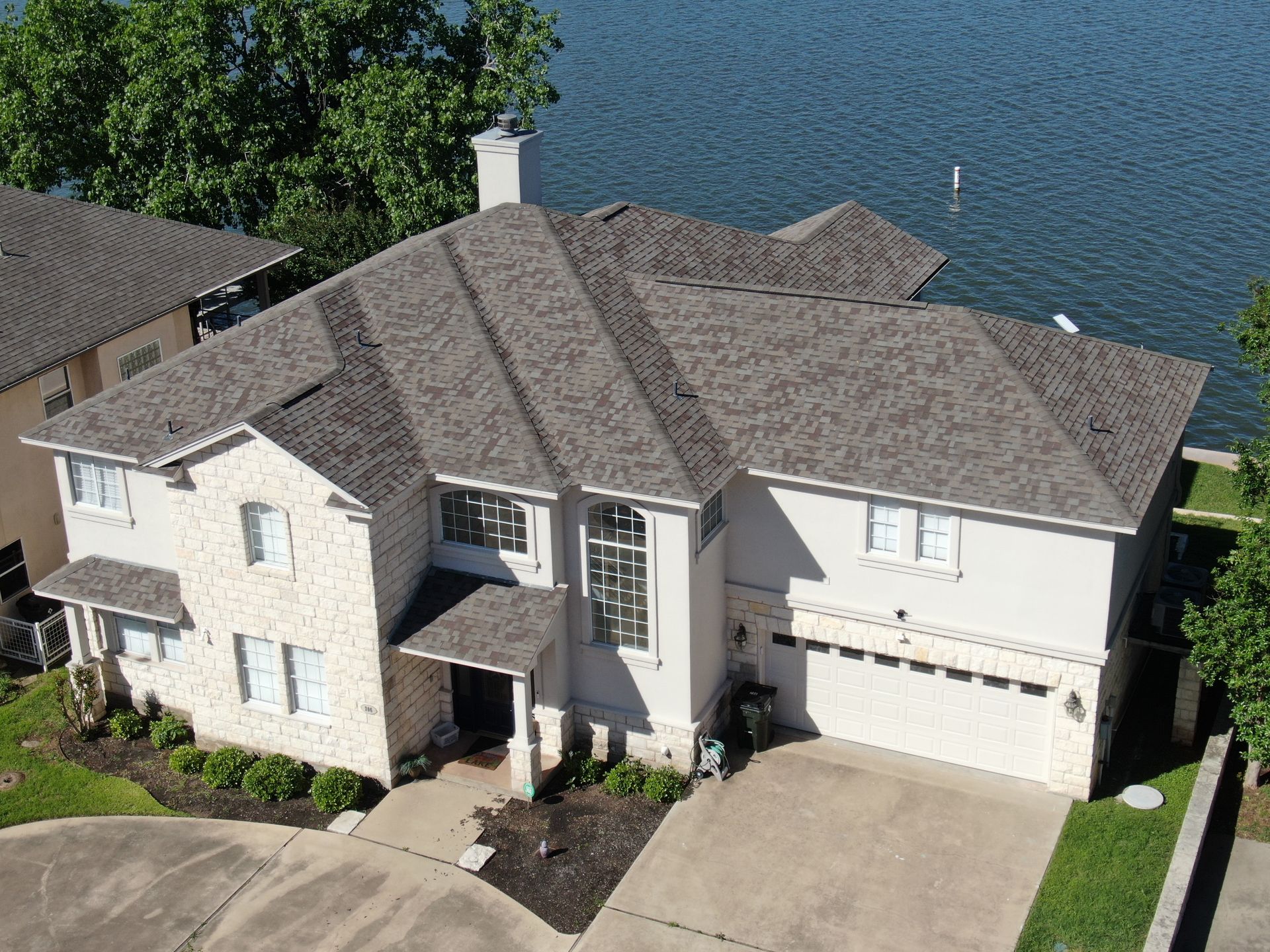 An aerial view of a large house next to a lake.