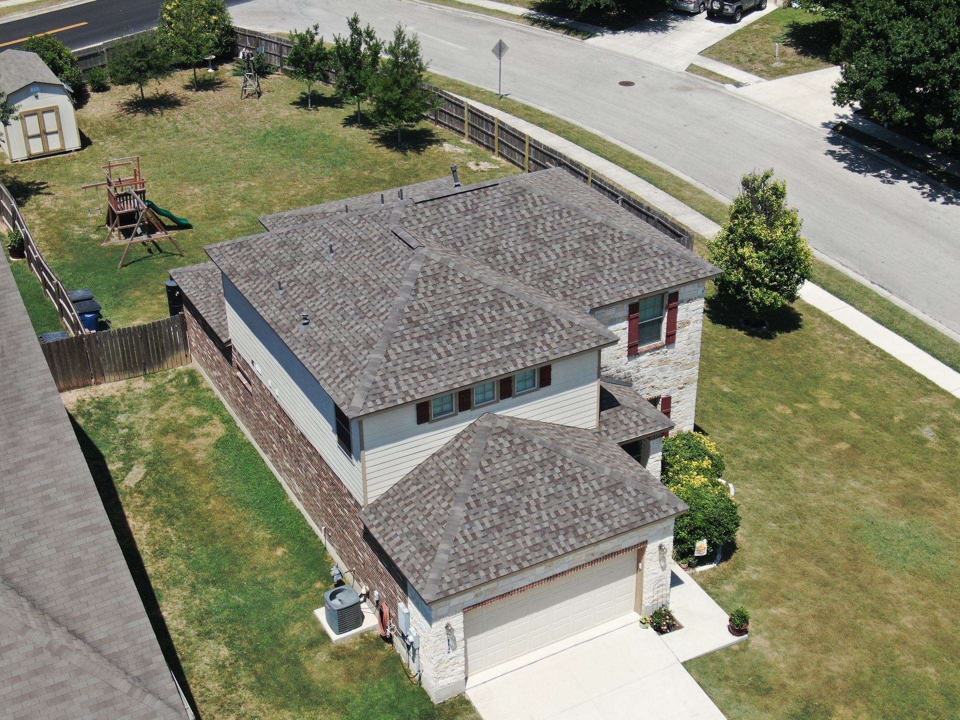 An aerial view of a house with a gray roof