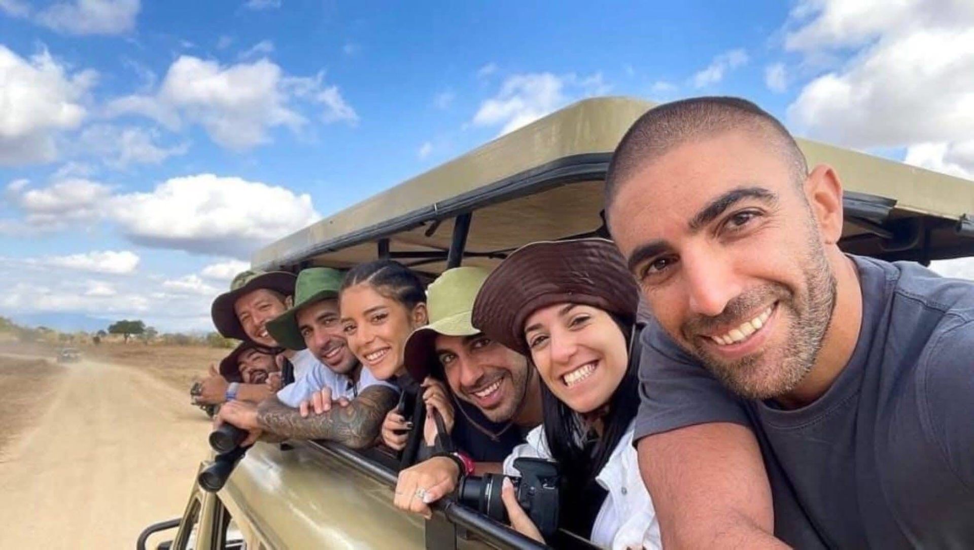 Group of safari tourists taking selfie from pop-up roof