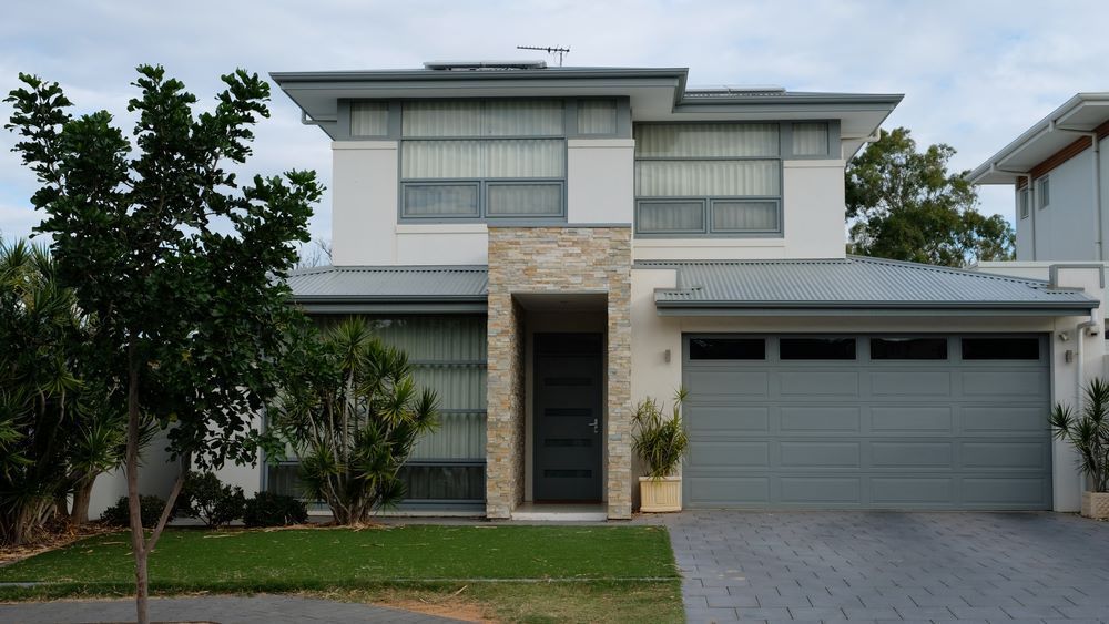 A Large White House With a Gray Garage Door — Airlie Beach Garage Doors In Proserpine, QLD