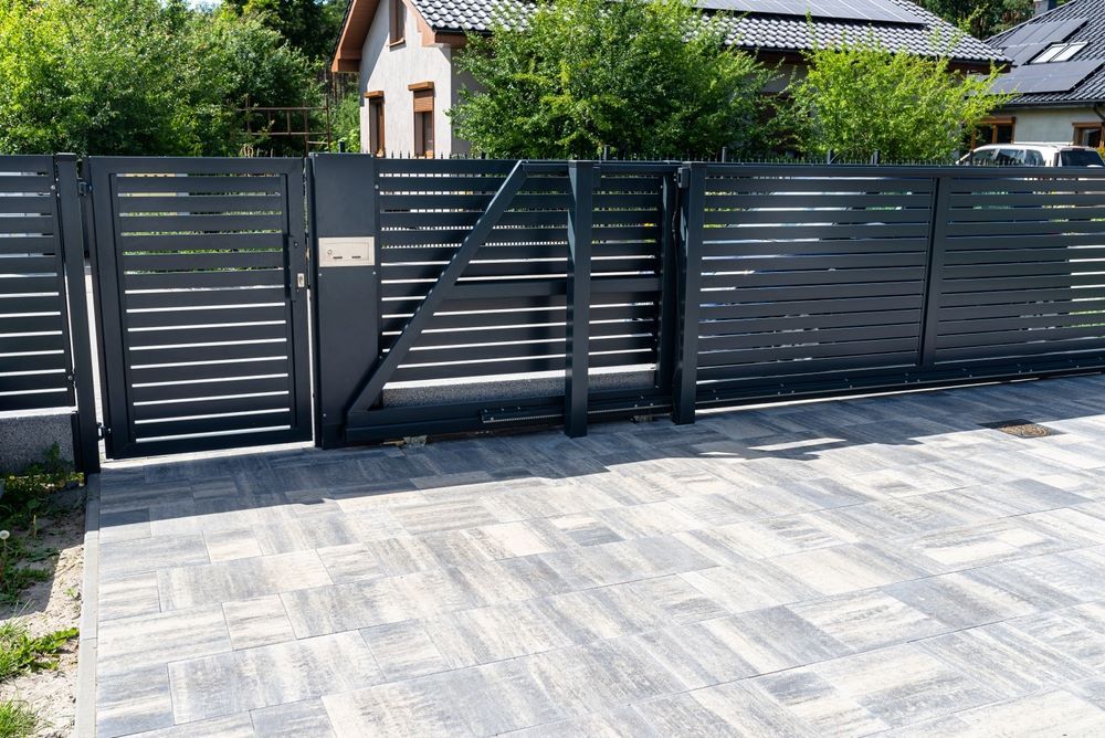 A Black Fence With a Gate in Front of a House  — Airlie Beach Garage Doors In Cannonvale, QLD