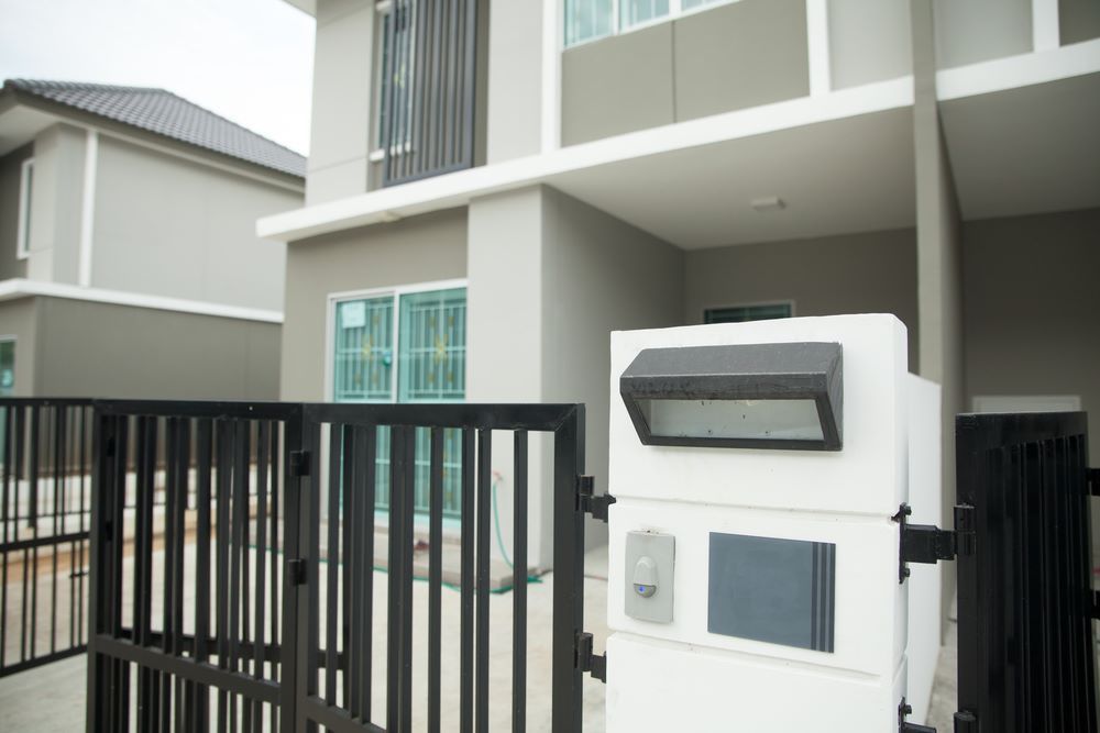 A House With a Fence and a Mailbox in Front of It — Airlie Beach Garage Doors In Cannonvale, QLD