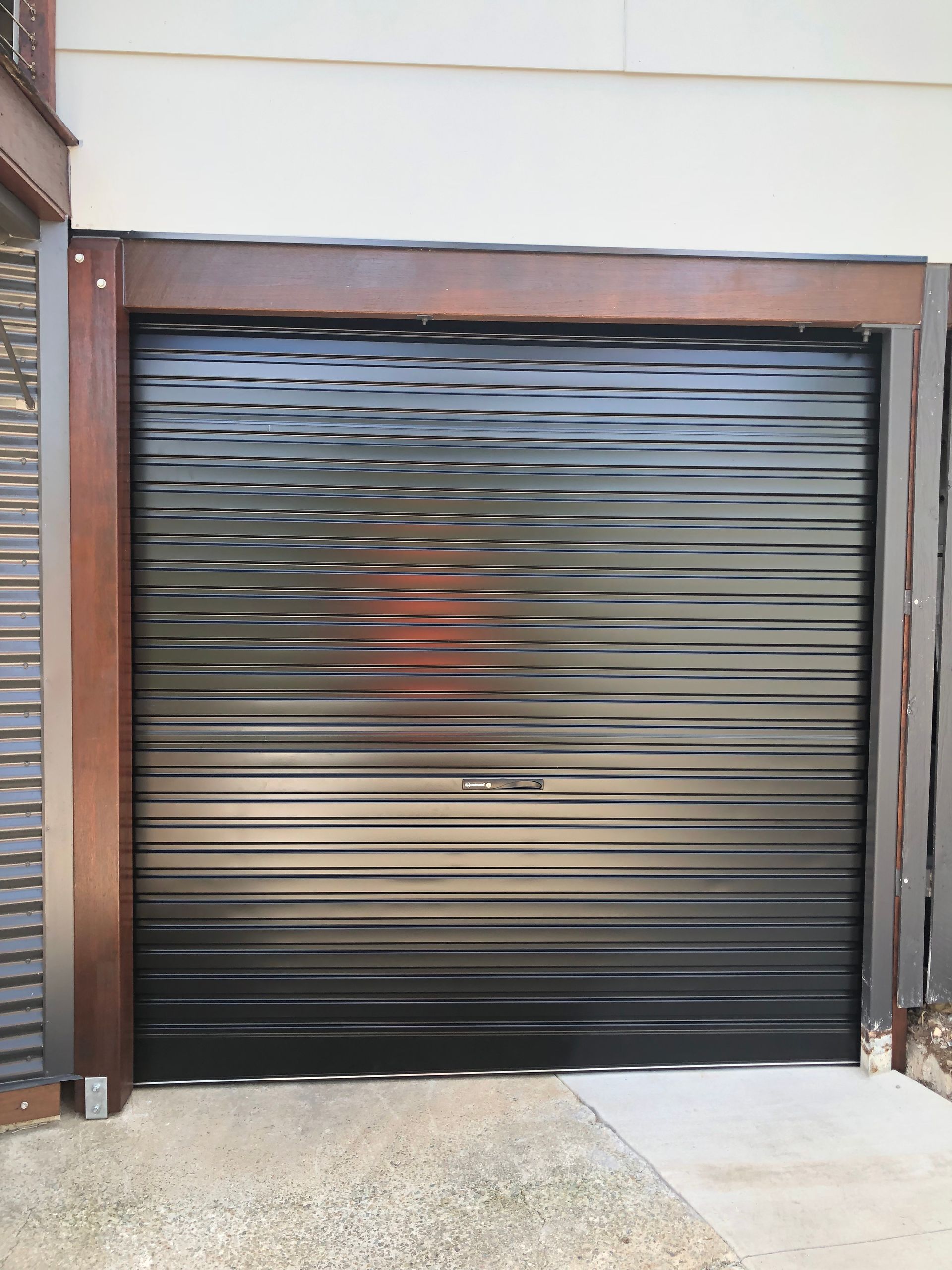 A White Garage Door is Open on the Side of a House — Airlie Beach Garage Doors In Airlie Beach, QLD