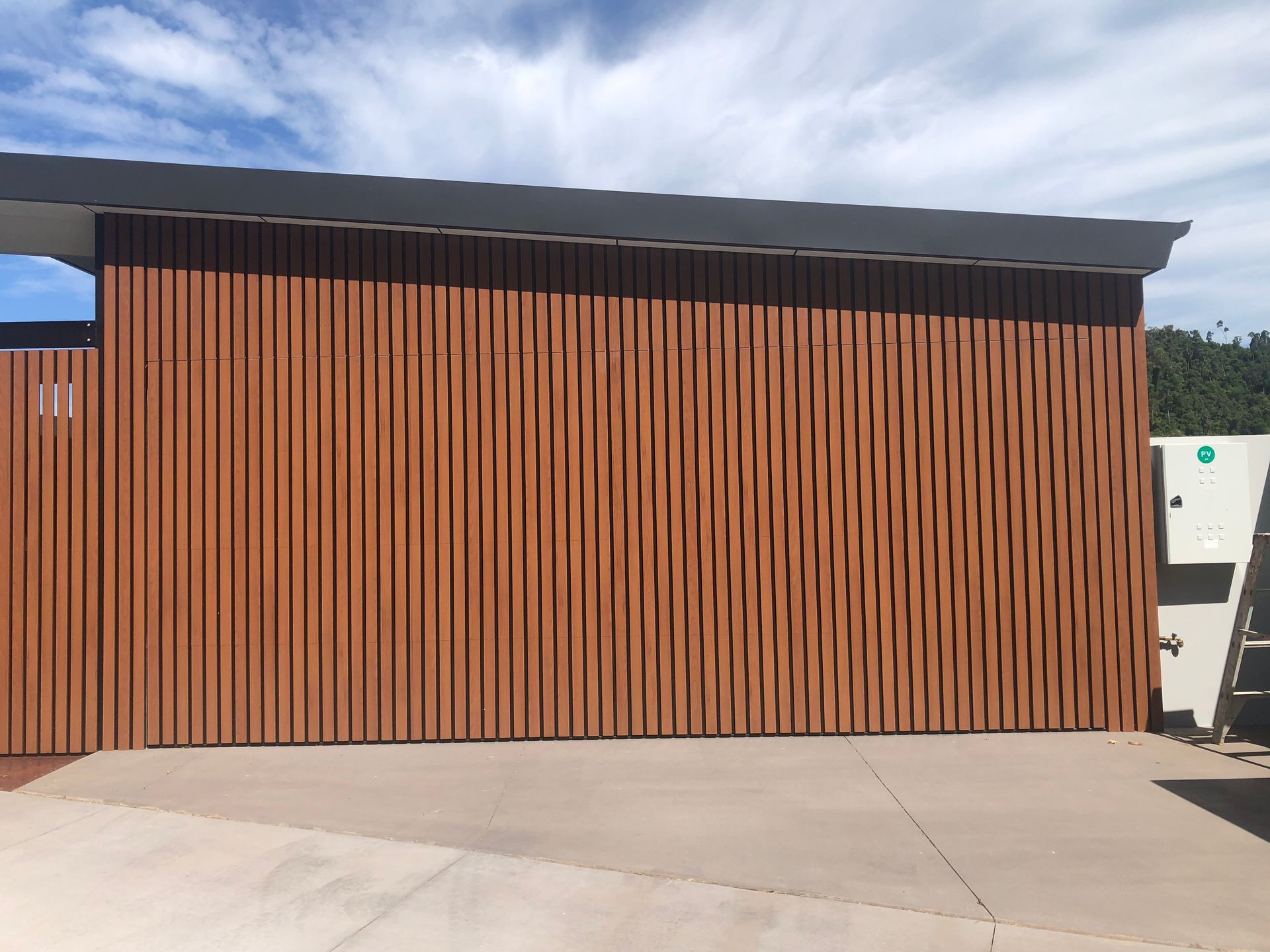 There Are Two White Garage Doors on the Side of a House — Airlie Beach Garage Doors In Cannonvale, QLD