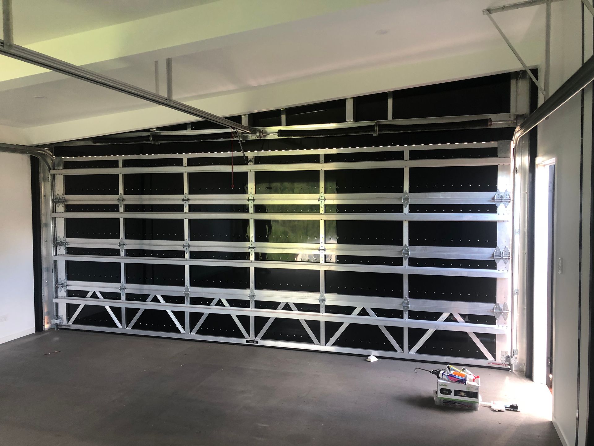 A White Garage Door is Closed and Empty — Airlie Beach Garage Doors In Proserpine, QLD