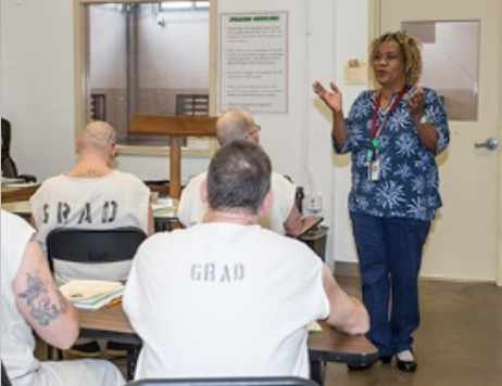 A group of people are sitting in a lecture hall listening to a speaker.