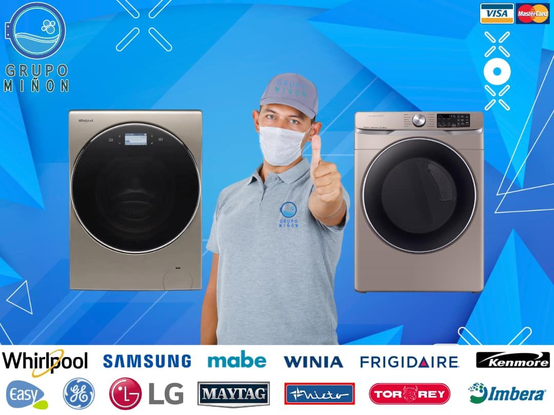 Un hombre que lleva una máscara hace un gesto de aprobación con el pulgar hacia arriba frente a dos lavadoras.