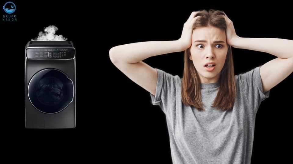 Una mujer sostiene su cabeza delante de una lavadora.