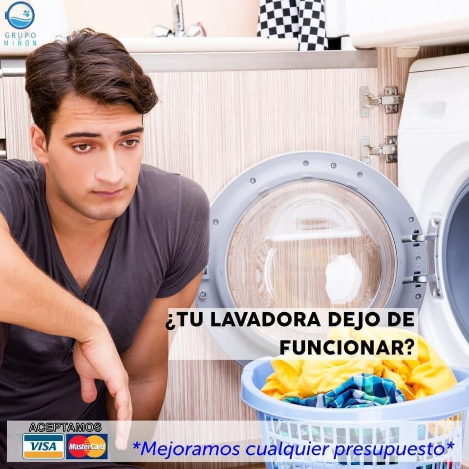 Un hombre está mirando una lavadora con una cesta de ropa delante de ella.