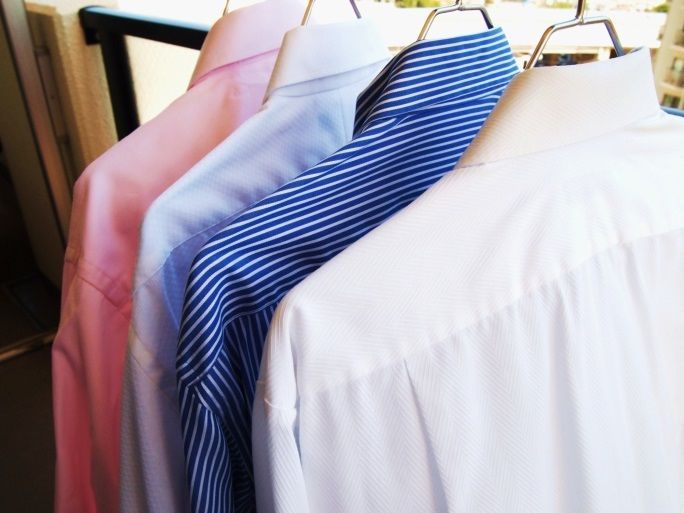 Un montón de camisas están colgadas en un perchero