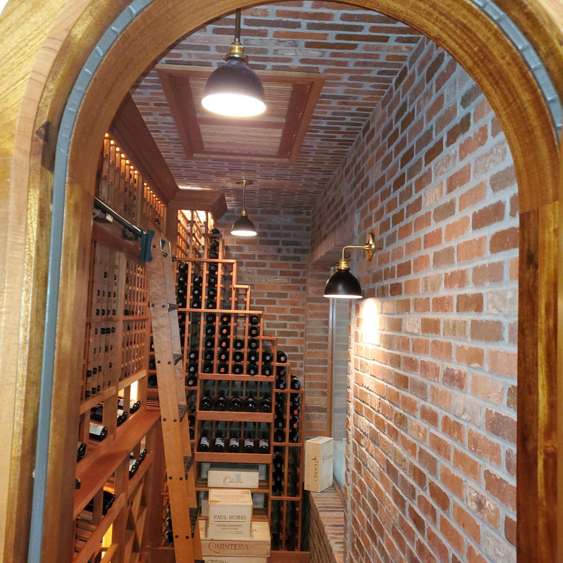 A wine cellar with a brick wall and a wooden archway — Pinellas County, FL —  R. J. Lange  & Son Inc.