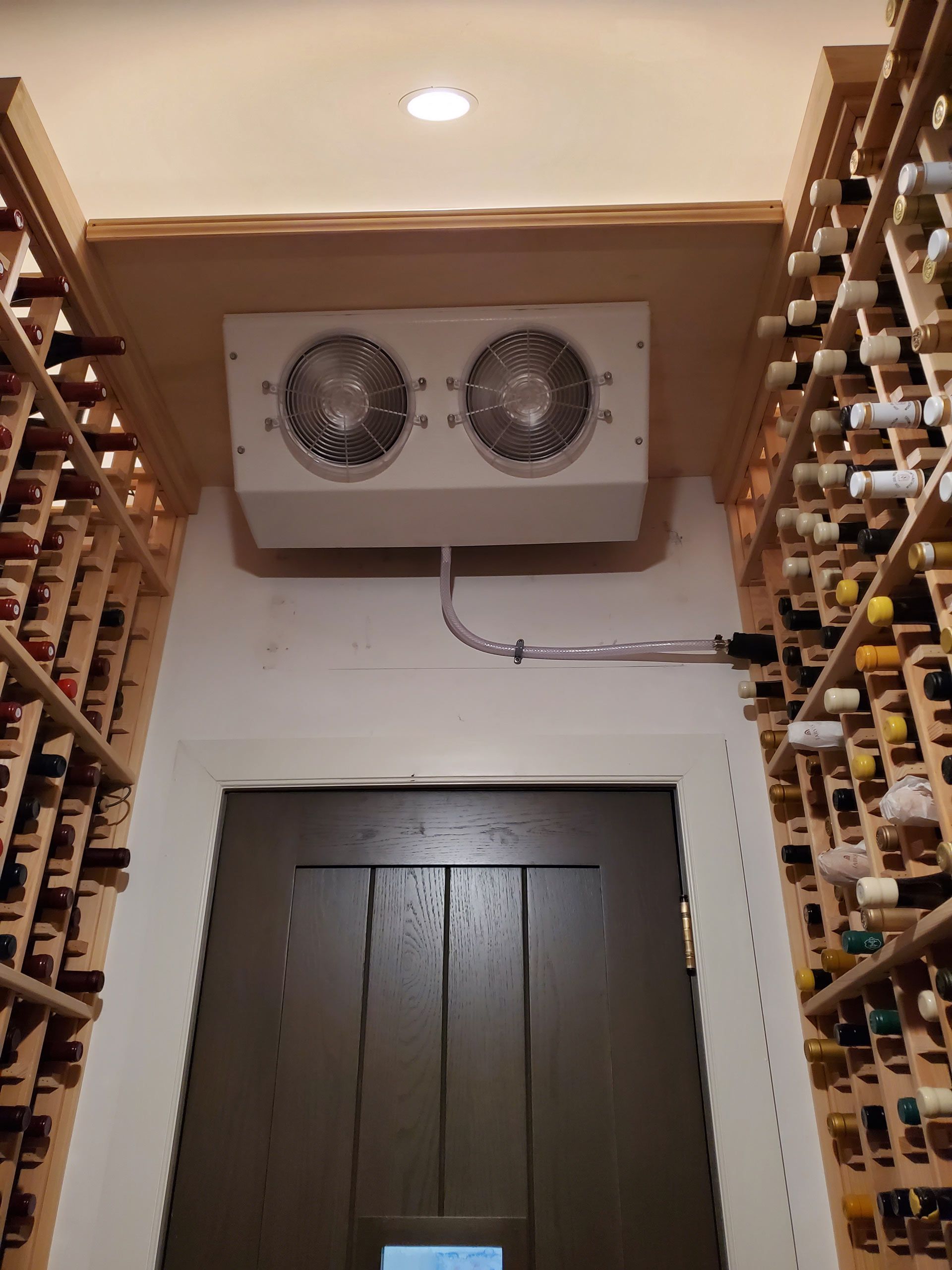 A wine cellar filled with lots of wine bottles and a door — Pinellas County, FL —  R. J. Lange  & Son Inc.