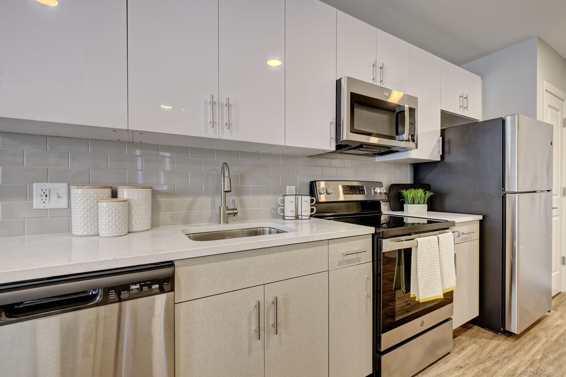 A kitchen with stainless steel appliances and white cabinets.