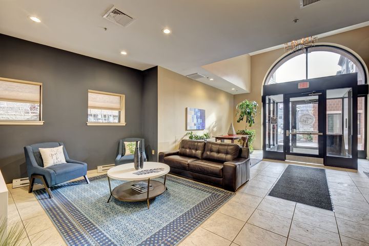 A living room with a couch , chairs , and a coffee table.