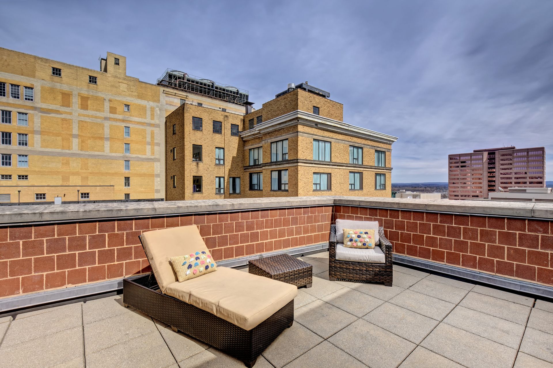 A brick building with a patio area with chairs and a table