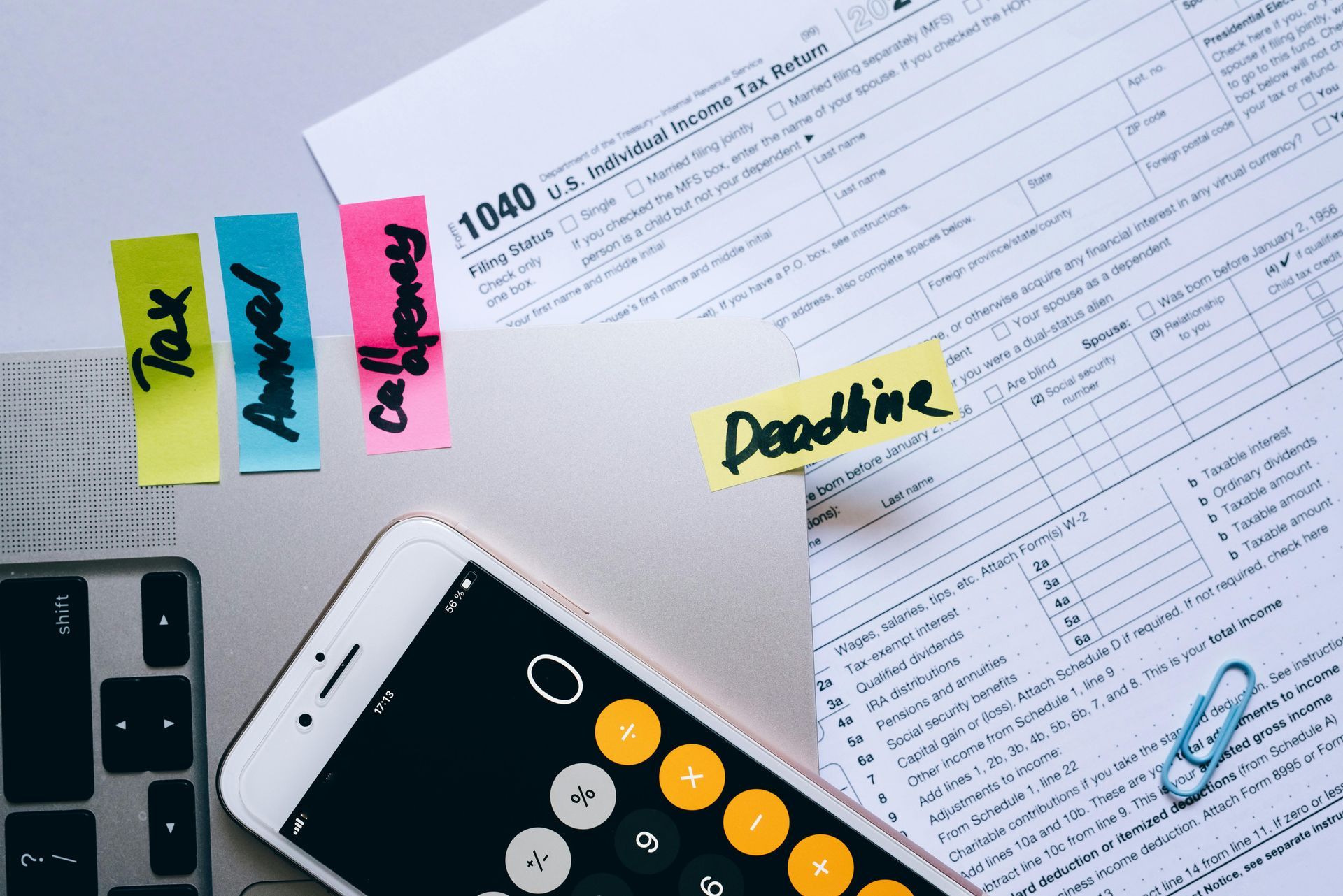 Tax documents, a calculator, and sticky notes with 
