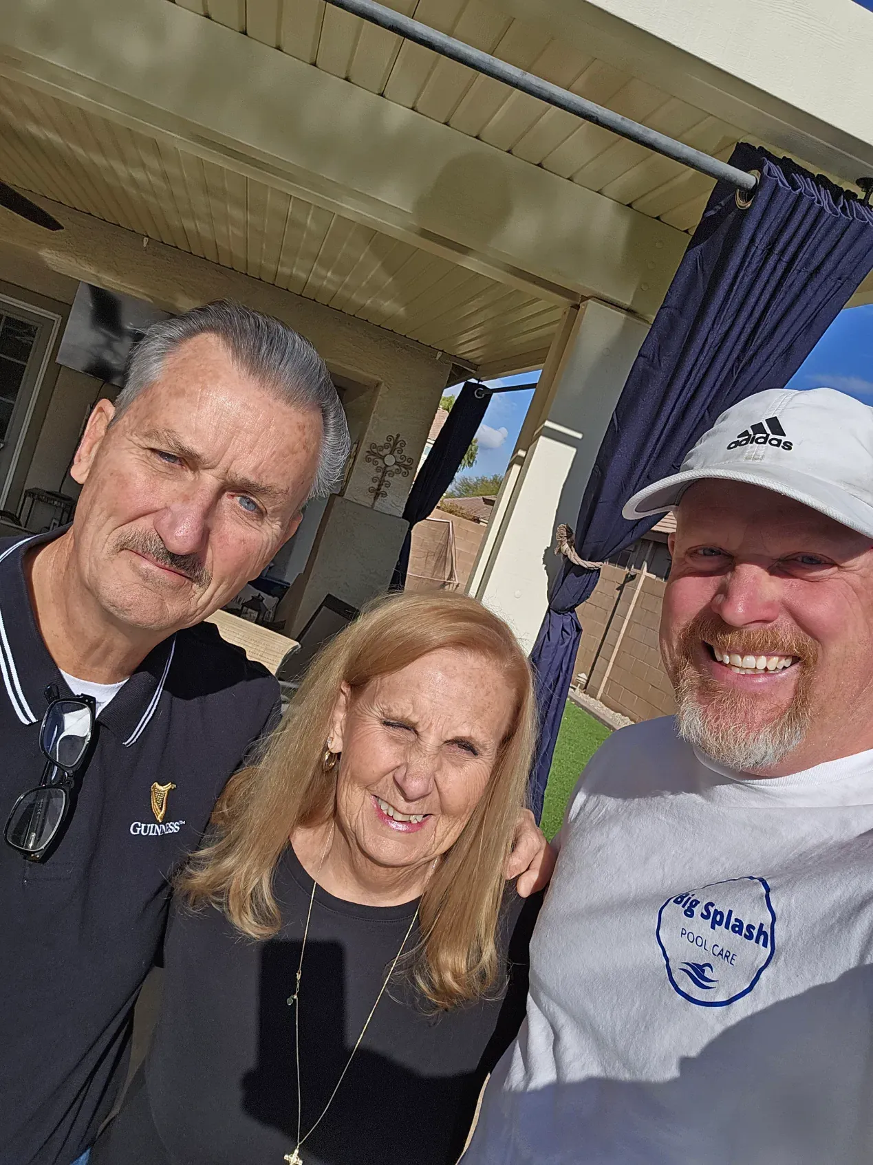Two men and a woman are posing for a picture together.